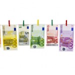 Geld-Euroscheine hängen an Wäscheklammern vor weißem Hintergrund